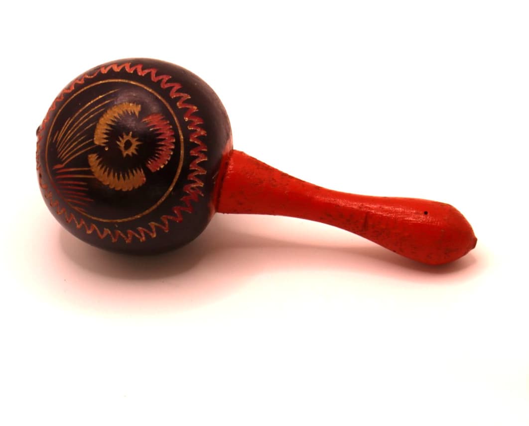 VTG Maraca with flower design and Aruba carved and painted. Handle is red.