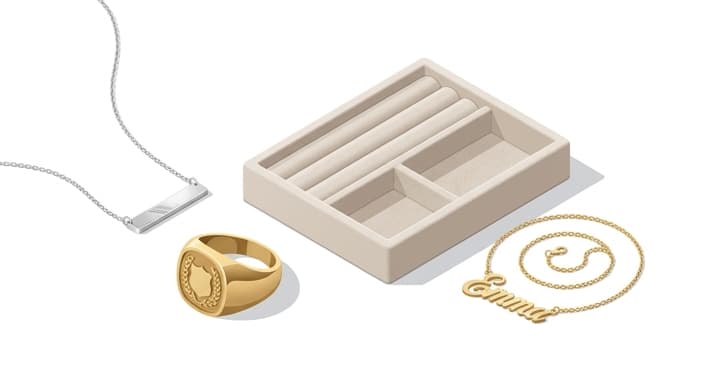A chic display of personalized jewelry featuring a dainty bar necklace, a signet ring, and a nameplate necklace.